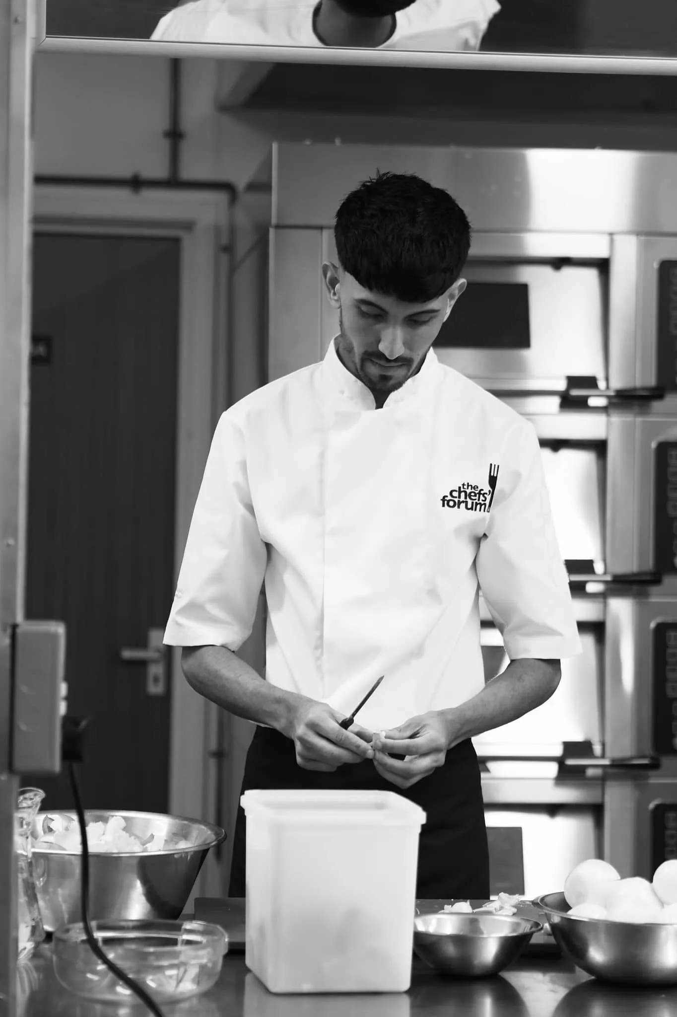Chef Jubz focused at the prep bench, knife in hand.